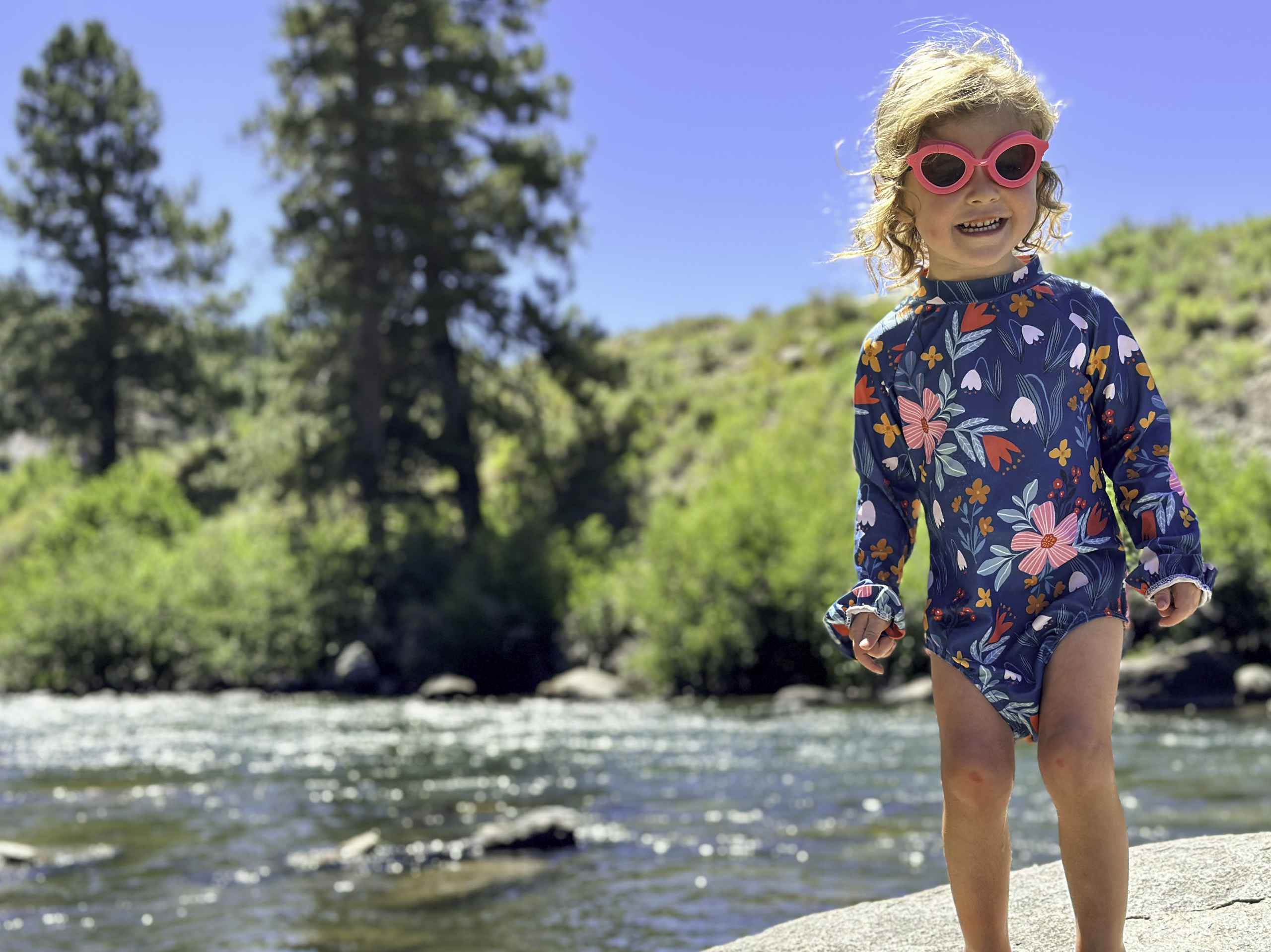 A young girl swimming in a stream.