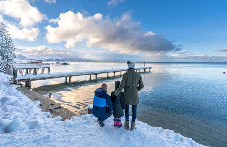 A family on the shore of Lake Tahoe in the winter.